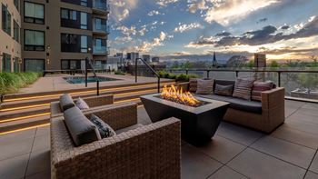 a patio with furniture and a fire pit on a rooftop